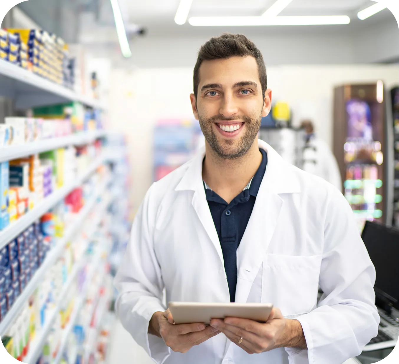 Pharmacist in a white coat holding a tablet in a pharmacy aisle